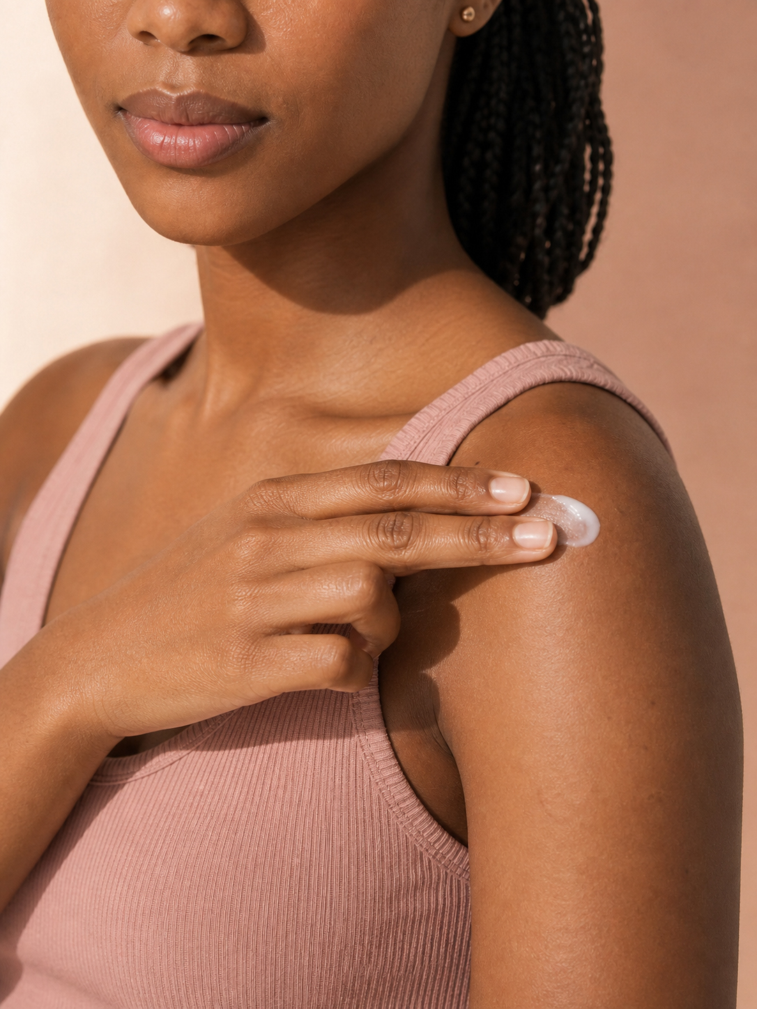 Sanaa applying skincare to her shoulder