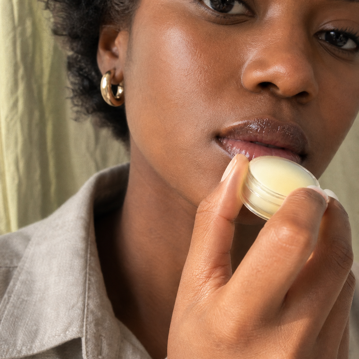 Close view of Amara bringing balm toward her lips